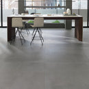 Modern office space with a long desk and stools on a grey tiled floor.