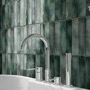 Bathroom basin and chrome tap with green tiled wall