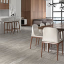 Modern kitchen and dining area with grey wood effect floor tiles, chairs, and a table.