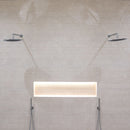 Shower with two chrome rain shower heads, shelf recess and textured beige wall tiles.