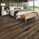 Bedroom with four poster bed and dark wooden floor.