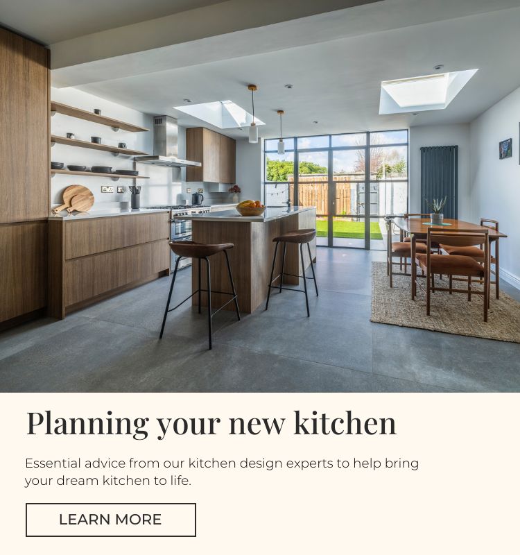 Modern kitchen with wooden cabinets and an island and large grey concrete effect floor tiles.