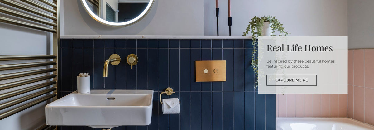 Bathroom with brushed brass fixtures and dark blue and pink metro tiles stacked vertically on the wall.