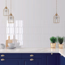 Modern kitchen with blue cabinets, white metro wall tiles and gold pendant lights.