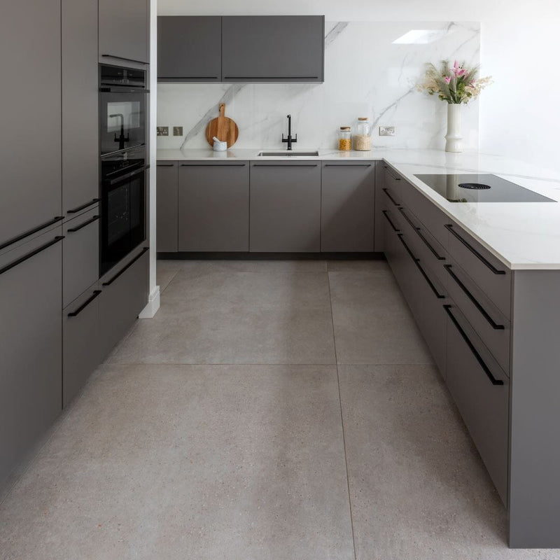 Modern kitchen with grey cabinets and white countertops and large grey floor tiles