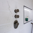 Textured white marble effect wall tiles and a shower valve