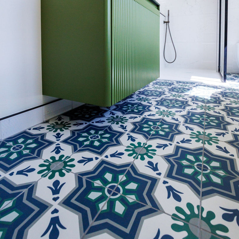 Bathroom with a green vanity unit and patterned floor tiles.