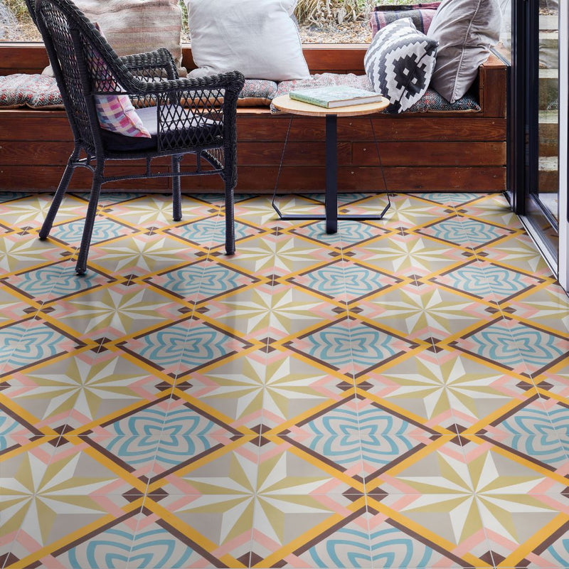 Patterned floor tiles in a geometric design with a chair and table in the background.