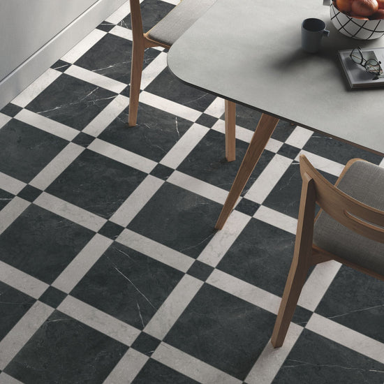 Classica black and white marble effect tiles laid in a Cassettone pattern underneath a dining table.