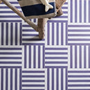 Blue and white striped tiles laid in a basketweave pattern.