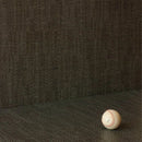 A close-up of a dark charcoal gray textured tile with a baseball in the lower right corner for scale.