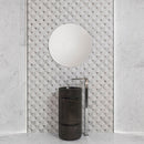 Bathroom feature wall with a round mirror mounted on a geometric patterned tile wall with light marble effect tiles on the side.