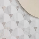 White and gray marble fan-shaped mosaic wall tiles with a repeating scallop pattern, shown with a circular mirror in the top right corner.