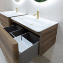 Bathroom vanity with wooden finish, white countertop and brushed brass tap.