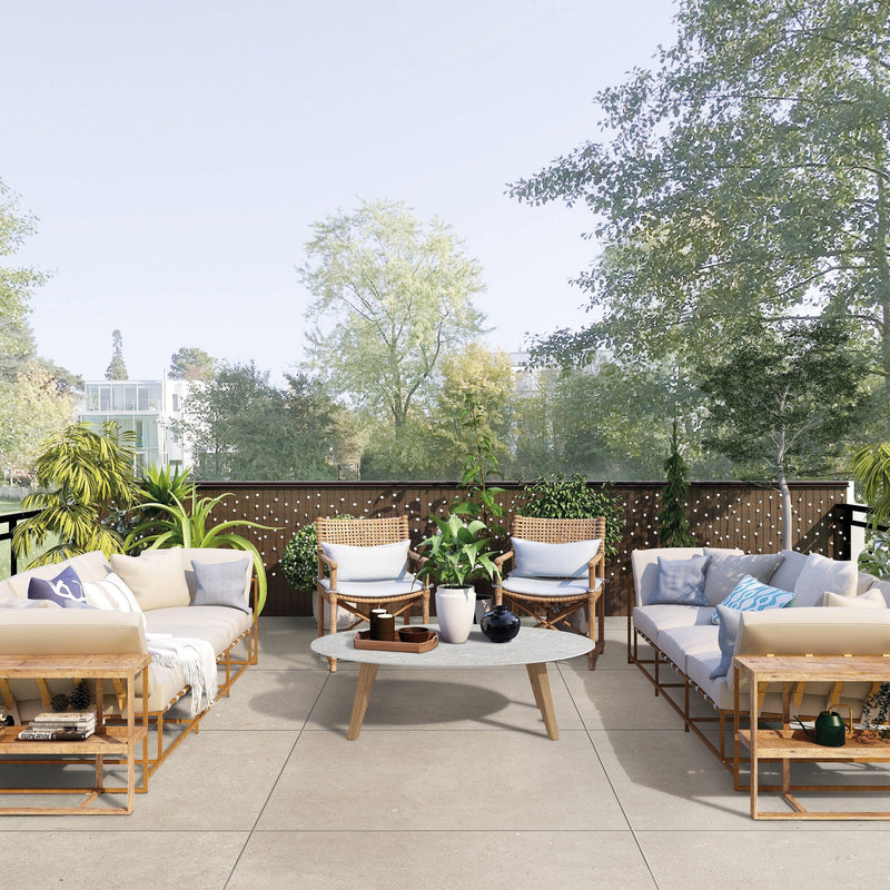 Outdoor patio with wooden furniture, cushions, and plants on a sunny day.