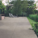 Patio with large square outdoor paving slabs, wooden garden furniture in a green outdoor setting
