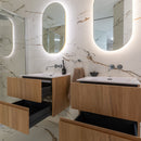 Modern bathroom with wooden vanities, marble effect tiled walls, and oval mirrors.