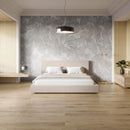 Modern bedroom with a bed, wood effect luxury vinyl flooring and a decorative wall behind the bed.
