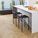 Modern kitchen with white island, black stools and wood effect herringbone luxury vinyl flooring.