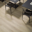 Wood effect luxury vinyl flooring with a dining table and chairs in the background.