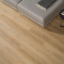 Wood effect luxury vinyl flooring with a grey sofa and black and grey patterned throw.