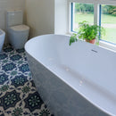 Bathroom with a white  freestanding bathtub and patterned floor tiles.