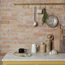 Marble kitchen counter and a terracotta brick wall