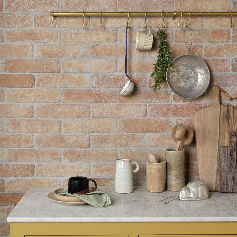 Marble kitchen counter and a terracotta brick wall