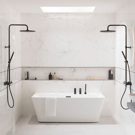 Modern bathroom with a freestanding bathtub, marble effect tiles and black fixtures.