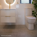 Modern bathroom with white vanity unit, white wall tiles and terrazzo effect floor tiles.