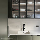 Kitchen with green cupboards and off white fluted wall tiles
