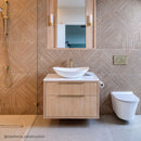 Bathroom with wooden vanity, white sink, and toilet against a texture wood effect tiled wall.