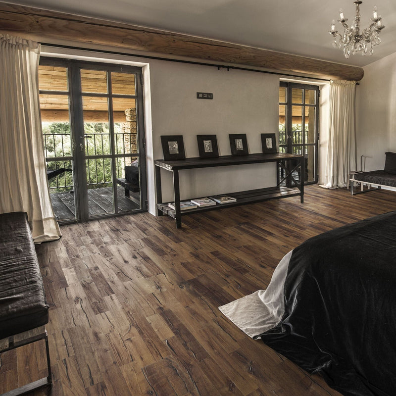 Bedroom with wooden flooring and a chandelier looking out on to a wooden veranda.