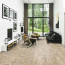 Living area with a large window and pale engineered wood flooring laid in a Dutch pattern.
