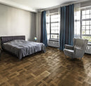 Bedroom with dark engineered wood flooring laid in a Dutch pattern.