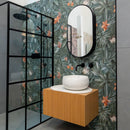 Bathroom with tropical print wall tiles, wooden vanity and black bathroom fittings