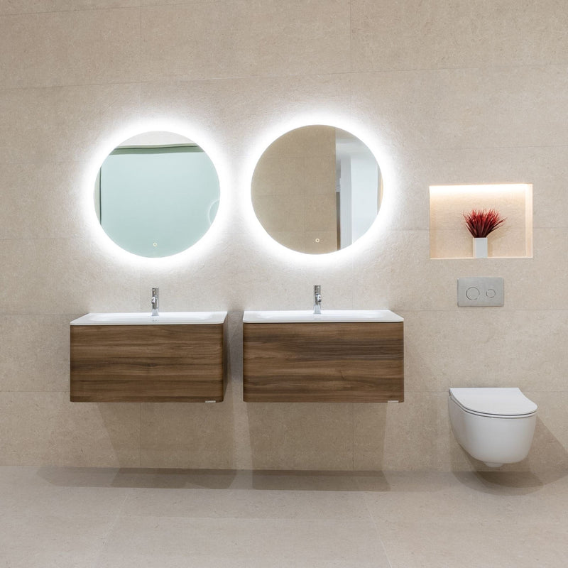 Bathroom with beige tiles, wooden vanities, round mirrors, and a wall-mounted toilet.
