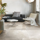 Modern living room with black sofa, white chair, and ottoman on a tiled floor.