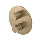 Round brushed brass shower control panel with two knobs on a white background