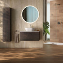 Bathroom with wooden vanity, round mirror, wood effect and travertine effect tiles and plant
