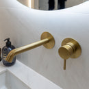 Brushed brass wall mounted basin mixer tap.