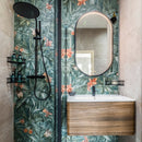 Bathroom with floral tiles, wooden vanity with a black tap and an oval mirror.