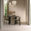 Dining room with a round table and chairs, pendant lights and beige floor tiles.