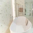 Bathroom with marble effect tiles nad freestanding bathtub.