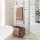 Bathroom with marble effect tiled walls, a towel rack with a brown towel, and a woven basket.