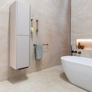 Modern bathroom with a freestanding bathtub, wall-mounted cabinet and beige stone effect tiles.