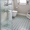 Bathroom with patterned floor tiles, shower, sink, and toilet.
