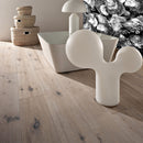 Modern interior with a white abstract sculpture on a wooden floor, a lamp, and woven baskets.